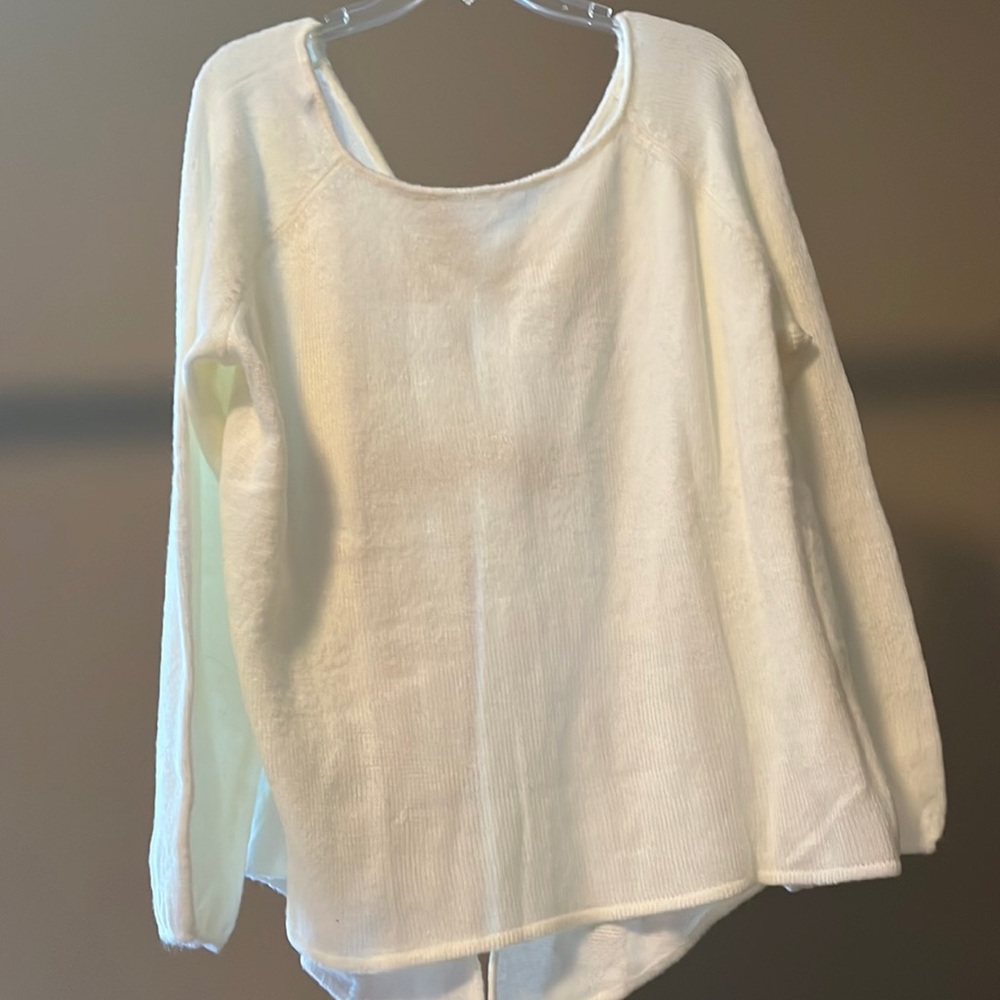 White sweater with open back and black bows
